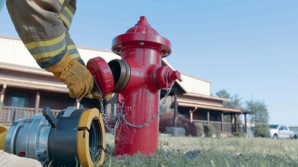 Firefighter connecting a hose to a fire hydrant.