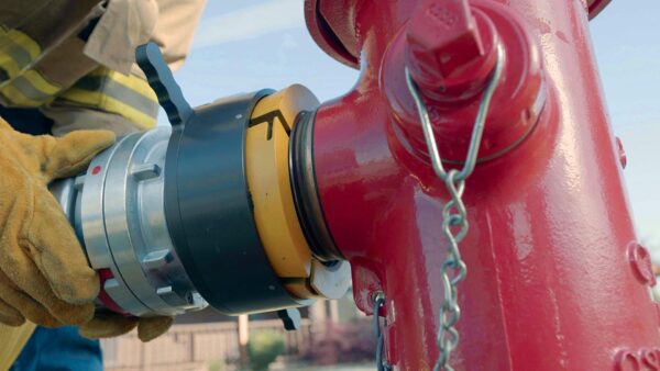 Firefighter connecting hose to hydrant.