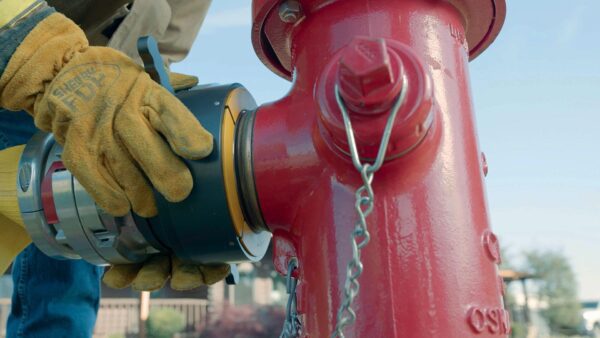 Firefighter connecting a hose to a hydrant.